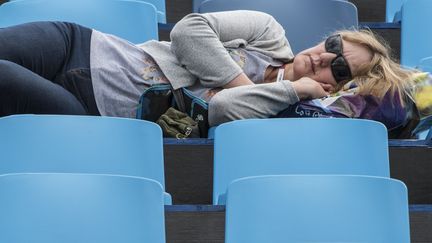 Une spectatrice dort lors de l'épreuve de dressage par équipe, aux Jeux de Rio de Janeiro (Brésil), le 12 août 2016.&nbsp; (JOHN MACDOUGALL / AFP)