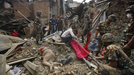 Secours et habitants tentent d'&eacute;vacuer les corps des victimes du s&eacute;isme qui a frapp&eacute; le N&eacute;pal,&nbsp;&agrave; Bhadgaon, dans la vall&eacute;e de Kathmandou, dimanche 26 avril 2015. (NIRANJAN SHRESTHA / AP / SIPA )