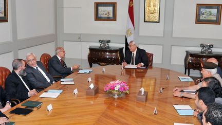 Le pr&eacute;sident &eacute;gyptien par interim Adly Mansour (au centre) et le leader politique Mohamed El-Baradei (&agrave; sa droite),&nbsp;lors d'une r&eacute;union avec les groupes d'opposition au Caire (Egypte), le 6 juillet 2013. (EGYPTIAN PRESIDENCY / AFP)