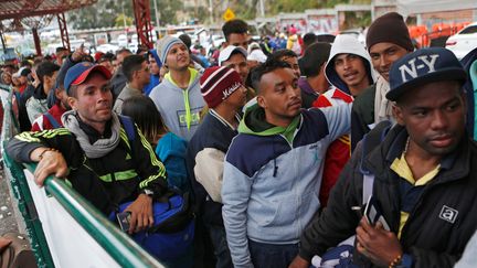 Des migrants vénézueliens se tiennent debout dans la file d'attente pour enregistrer leur sortie de Colombie et leur entrée au Pérou, au pont international ed Rumichaca (Colombie), le 18 août 2018. (LUISA GONZALEZ / Reuters)