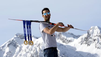 Le champion olympique Martin Fourcade pose avec ses trois m&eacute;dailles obtenues &agrave; Sotchi, deux en or et une argent, le 23 f&eacute;vrier 2014. (FRANCK FIFE / AFP)