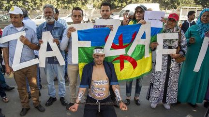 Les partisans du mouvement marocain Al-Hirak al-Shaabi brandissent des pancartes et des slogans appelant à la libération du leader du mouvement Nasser Zefzafi devant la Cour d'appel de Casablanca lors de son procès le 24 octobre 2017.  (Fadel Senna/AFP)