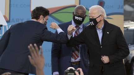 Joe Biden (à droite), avec les deux candidats démocrates aux sénatoriales partielles de Géorgie (Etats-Unis), le 4 janvier 2021. (JIM WATSON / AFP)