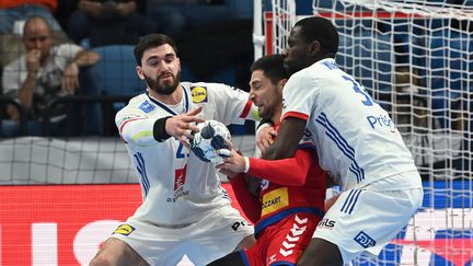 Karl Konan (à droite) entoure le Serbe Lazar Kukic avec Ludovic Fabregas lors de la rencontre de l'Euro 2022 entre la France et la Serbie, le 17 janvier 2022, à Bratislava (Slovaquie). (ATTILA KISBENEDEK / AFP)