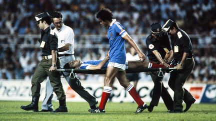 Le joueur français Patrick Battiston sort sur une civière après un choc avec le gardien allemand Harald Schumacher, lors de la demi-finale du Mondial 1982 à Séville. (AFP)