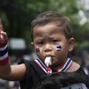 Un enfant est assis sur les &eacute;paules d'un manifestant antigouvernement, dans un rassemblement &agrave; Bangkok (Tha&iuml;lande), le 2 avril 2014. (NICOLAS ASFOURI / AFP)