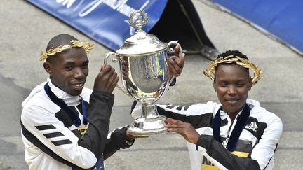 Benson Kipruto et&nbsp;Diana Kipyogei soulèvent leur trophée au 125e marathon de Boston, le 11 octobre 2021. (JOSEPH PREZIOSO / AFP)