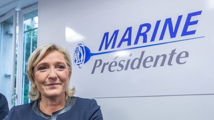 Marine Le Pen, présidente du Front national, devant son nouveau logo lors de&nbsp;l'inauguration de ses locaux de campagne, à Paris, le 16 novembre 2016. (JULIEN MATTIA / NURPHOTO / AFP)