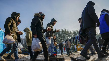 Des migrants reçoivent une aide alimentaire en Biélorussie, près de la frontière avec la Pologne, le 1er décembre 2021. (SEFA KARACAN / ANADOLU AGENCY)