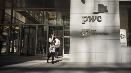 Une femme sort des locaux du cabinet&nbsp;PricewaterhouseCoopers &agrave; New York (Etats-Unis), en octobre 2011. (RICHARD B. LEVINE/ SIPA USA)