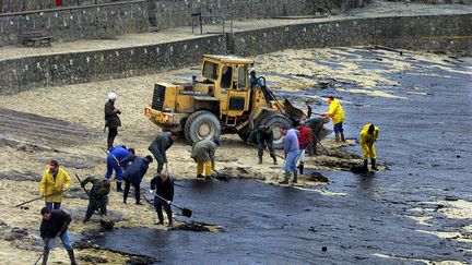 Des bénévoles nettoient la plage de Batz-sur-Mer (Loire-Atlantique), le 27 décembre 1999, après la marée noire due au naufrage du pétrolier "Erika". (REUTERS)