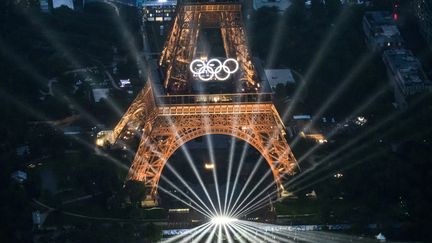 La tour Eiffel se pare de lumières, le 26 juillet 2024, lors de la cérémonie d'ouverture des Jeux olympiques de Paris. (LIONEL BONAVENTURE / AFP)