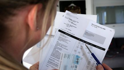 Une femme consulte sa feuille de paie. (VANESSA MEYER / MAXPPP)