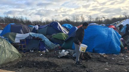 Un migrant aménage un espace pour installer une tente dans le camp de Grande-Synthe (Nord), mardi 29 décembre 2015.&nbsp; (F. MAGNENOU / FRANCETV INFO)