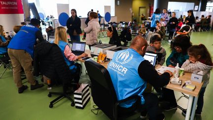 Des réfugiés ukrainiens qui ont fui vers la Pologne dans un centre d'inscription du Haut Commissariat des Nations unies pour les réfugiés (HNCR), à Cracovie, en Pologne, le 13 avril 2022. (BEATA ZAWRZEL / NURPHOTO / VIA AFP)