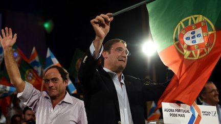 Pedro Passos Coelho, Premier ministre du Portugal (à droite), avec le drapeau national à la main, en campagne électorale le 27 septembre 2015. Le Parti social démocrate (à ne pas confondre avec le Parti socialiste) est au pouvoir avec les conservateurs. Cette alliance, Portugal a frente (Portugal en avant) brigue un nouveau mandat. (FRANCISCO LEONG / AFP)