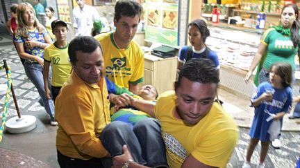 Une supportrice victime d'une crise cardiaque, le 1er juillet 2006, &agrave; Rio de Janeiro (Br&eacute;sil),&nbsp;pendant le quart de finale du Mondial entre la France et le Br&eacute;sil, alors que les Bleus viennent d'ouvrir la marque. Admise &agrave; l'h&ocirc;pital, elle en est sortie saine et sauve. (CAIO LEAL / AFP)