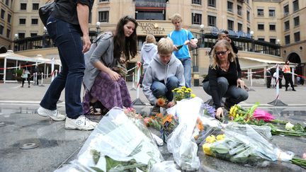 Pr&egrave;s d'une statue de Nelson Mandela &agrave; Johannesbourg, des gens d&eacute;posent des fleurs, le 6 d&eacute;cembre 2013. (STEPHANE DE SAKUTIN / AFP)