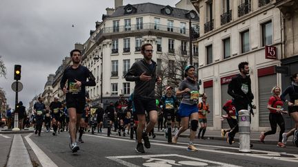 Dans les rues de Paris, les participants au traditionnel marathon de Paris, le 2 avril 2023. (NOEMIE COISSAC / AFP)