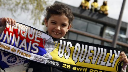 Un enfant pose avec l'&eacute;charpe de la finale de la Coupe de France dans les rues de Neufch&acirc;tel-en-Bray, le 25 avril 2012.&nbsp; (CHARLY TRIBALLEAU / AFP)