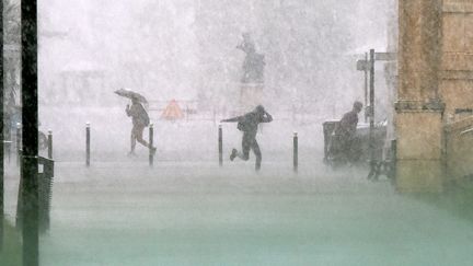 Des passants&nbsp;tentent de s'abriter lors d'un violent orage sur Montpellier (Hérault), le 6 septembre 2022. (MAXPPP)