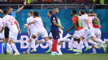 Après son tir au but manqué, la solitude de Kylian Mbappé contraste avec l'immense joie des Suisses, qualifiés pour la première fois de leur histoire en quarts de finale d'un Euro.&nbsp; (FRANCK FIFE / AFP)