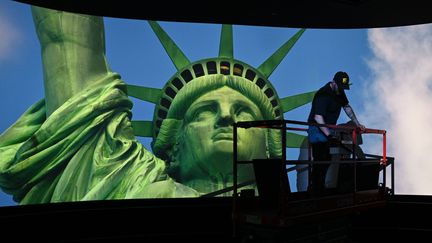 Un ouvrier travaille sur le plafond d'une pièce&nbsp;durant la projection d'un film dans le nouveau musée de la Statue de la Liberté à Liberty Island (New York, Etats-Unis), le 13 mai 2019. (TIMOTHY A. CLARY / AFP)