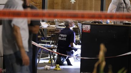 Des policiers examinent le restaurant de Tel Aviv (Israël) où une fusillade a fait au moins quatre morts, mercredi 8 juin 2016. (JACK GUEZ / AFP)