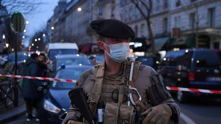 Un soldat de la force sentinelle monte la garde le 20 décembre 2021 rue d'Aligre à Paris où un homme a pris deux femmes en otage. (ALAIN JOCARD / AFP)