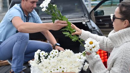 Un homme livre des fleurs, de la nourriture et de l'eau à des manifestants à Minsk. (SERGEI GAPON / AFP)