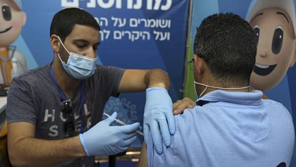 Un soignant administre une troisième dose de vaccin Pfizer-BioNTech dans un centre de vaccination à Jérusalem, le 8 août 2021. (MENAHEM KAHANA / AFP)