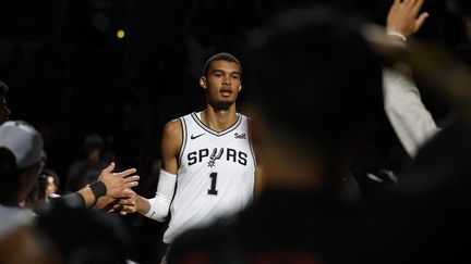 Victor Wembanyama fait son entrée sur le parquet de la Frost Bank Center de San Antonio, pour affronter les Houston Rockets en match de préparation à la saison NBA, le 16 octobre 2023. (RONALD CORTES / AFP)