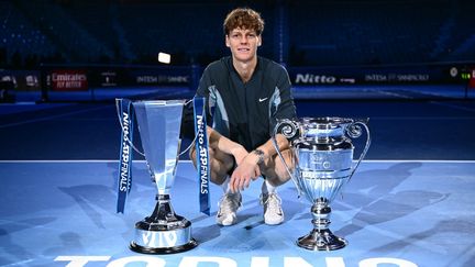 L'Italien Jannik Sinner pose avec le trophée du Masters et celui du numéro 1 mondial, le 17 novembre 2024 à Turin (Italie). (MARCO BERTORELLO / AFP)