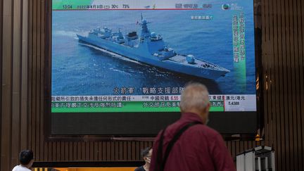 Un homme regarde un reportage sur un navire de guerre chinois dans un centre commercial de Hong Kong, le 3 août 2022. Photo d'illustration. (JEROME FAVRE / MAXPPP)