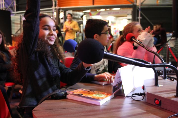 Depuis le Salon du livre jeunesse à Montreuil (Seine-Saint-Denis), des collégiens ont interviewé une auteure au micro de franceinfo junior, avec la journaliste Céline Asselot. (FRANCEINFO JUNIOR / RADIO FRANCE)