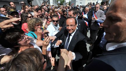 Le pr&eacute;sident Fran&ccedil;ois Hollande salue des habitants de La Roche-sur-Yon (Vend&eacute;e), apr&egrave;s une visite de l'agence locale de P&ocirc;le emploi, le 6 ao&ucirc;t 2013. (FRANK PERRY / AFP)