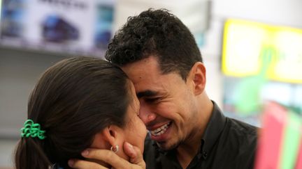 Juan Guaracan étreint sa femme Paola Fernandez à leur arrivée au terminal de bus à Lima (Pérou), le 23 août 2018. (GUADALUPE PARDO / REUTERS)