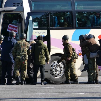 Survivors helped by the military board a bus to reach an evacuation site in Kanazawa (KARYN NISHIMURA / RADIO FRANCE)