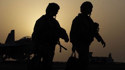 Des pilotes de chasse am&eacute;ricains, le 10 ao&ucirc;t 2014, sur le pont du porte-avion "George H.W. Bush", stationn&eacute; dans le golfe persique. (HASAN JAMALI / AP / SIPA)