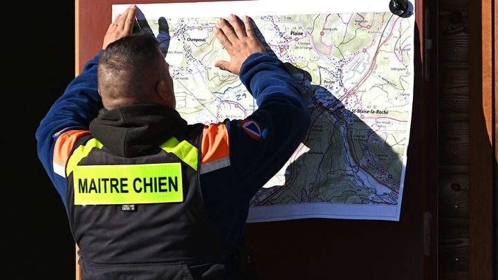 Un maître-chien de la Protection civile française regarde une carte alors qu'il participe à la recherche de Lina, le 26 septembre 2023. (PATRICK HERTZOG / AFP)