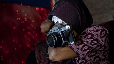 Amput&eacute;e &agrave; l'&acirc;ge de 12 ans de ses avant-bras, cette Indon&eacute;sienne est aujourd'hui &agrave; 44 ans devenue photographe, Purworejo (Indon&eacute;sie), le 13 mars 2012. (ULET IFANSASTI / GETTY IMAGES)