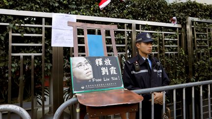 Une pancarte demandant la fin du placement en résidence surveillée de Liu Xia, veuve du dissident chinois et prix Nobel de la Paix Liu Xiaobo, devant le bureau de liaison du gouvernement chinois à Hong Kong, le 25 décembre 2017. (TYRONE SIU / REUTERS)