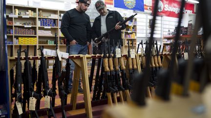 2 hommes choisissent une arme dans une armurerie à Merrimack (New Hampshire). (DOMINICK REUTER / AFP)