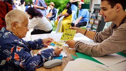 Une femme reçoit des explications sur le chèque alimentaire Vital'im. (CAMILLE MARIGAUX - FRANCEINFO)