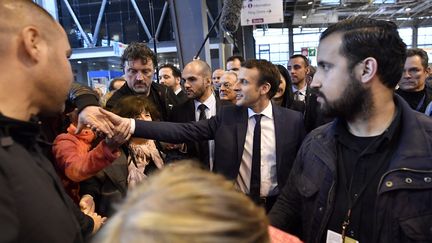 Emmanuel Macron et Alexandre Benalla (à droite), responsable de la sécurité du candidat pendant sa campagne, lors d'une visite au Salon de l'agriculture, le 1er mars 2017 à Paris.&nbsp; (LIONEL BONAVENTURE / AFP)