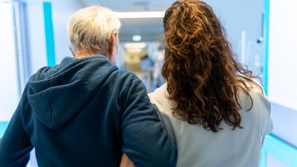 Un patient d'un service de gériatrie est soutenu par une soignante, le 23 juin 2023, à l'hôpital Saint-Camille de Bry-sur-Marne (Val-de-Marne). (ALINE MORCILLO / HANS LUCAS / AFP)