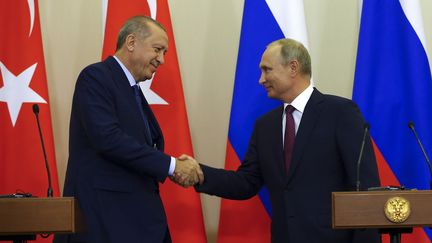 Le président turc Recep Tayyip Erdogan et son homologue Vladimir Poutine se serrent la main après une rencontre au sujet de la Syrie, le 17 septembre 2018 à Sotchi (Russie). (HALIL SAGIRKAYA / AFP)