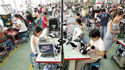 Des ouvriers travaillent dans l'usine Yue Yuen,&nbsp;&agrave; Dongguan, une ville du sud de la Chine, le 20 septembre 2005. (LANG SHUCHEN / IMAGINECHINA / AFP)