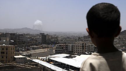 Un gar&ccedil;on regarde des bombardements de la coalition arabe sur Sanaa, la capitale y&eacute;m&eacute;nite, le 21 avril 2015. (HANI ALI / NURPHOTO / AFP)