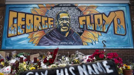 Des fleurs sont déposées sous une&nbsp;fresque en hommage à George Floyd, à Minneapolis (Minnesota, Etats-Unis), le 1er juin 2020. (STEPHEN MATUREN / GETTY IMAGES NORTH AMERICA / AFP)